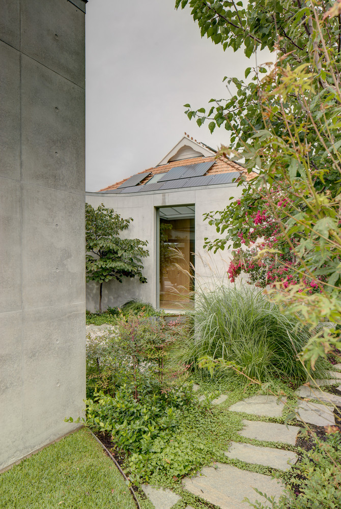 Lối vào được phủ kín bởi thảm cỏ, cây và hoa.