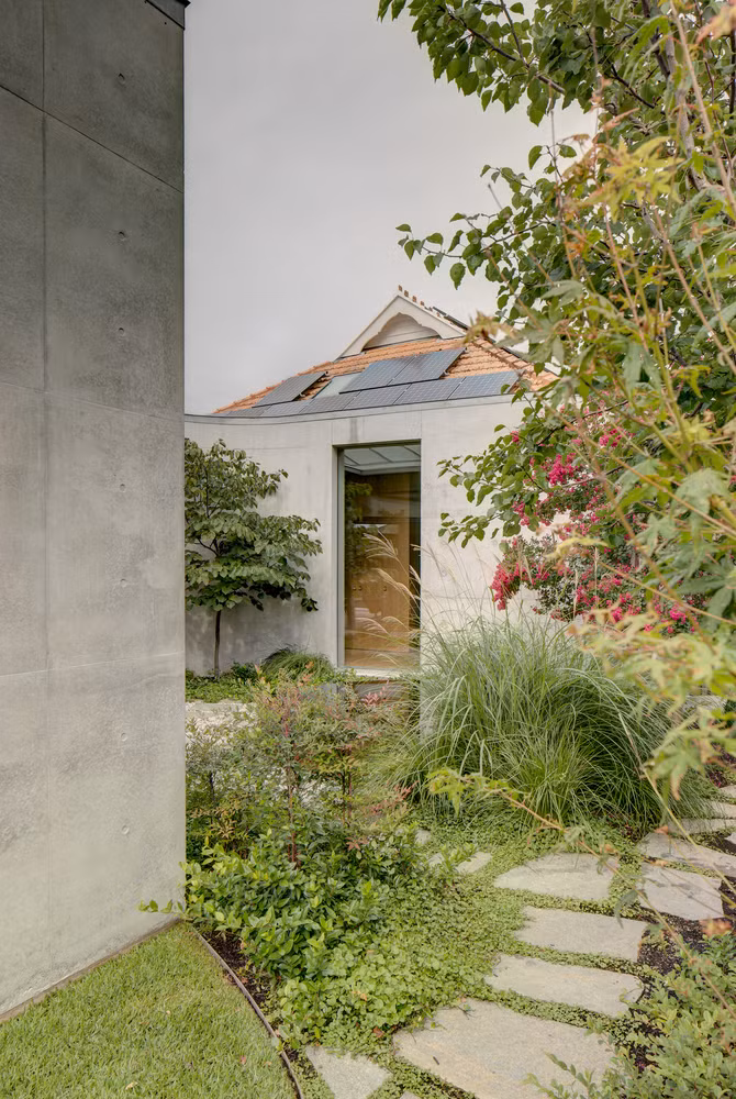 Lối vào được phủ kín bởi thảm cỏ, cây và hoa.