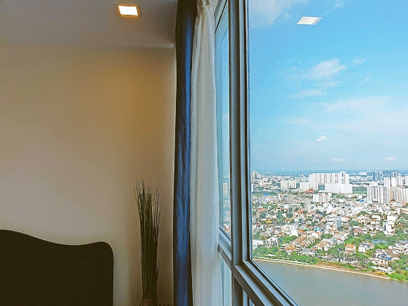 Phòng ngủ với view nhìn ra sông Sài Gòn và có thể ngắm cảnh thành phố từ trên cao.