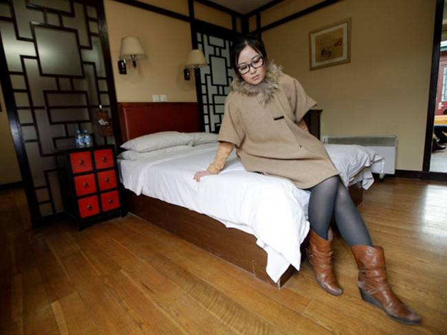 Cô ngồi lên giường để xem xét kết cấu và độ cứng của nệm.