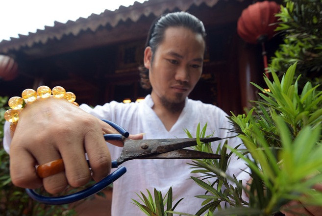 Những lúc rảnh rỗi, nghệ sĩ Vượng Râu thường chăm sóc, cắt tỉa cây cối, chơi đùa với các con trong khu biệt phủ. Ảnh: Zing.