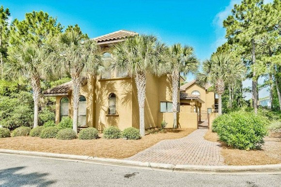 Biệt thự của Hồng Ngọc rộng 987m2, bên ngoài được sơn màu vàng, xung quanh có nhiều cây xanh.