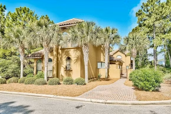 Biệt thự của Hồng Ngọc rộng 987m2, bên ngoài được sơn màu vàng, xung quanh có nhiều cây xanh.