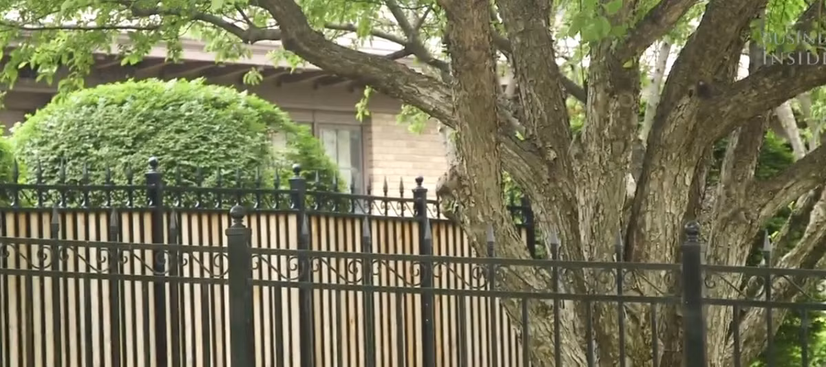 Bên ngoài nhà có hàng rào và gắn camera an ninh.