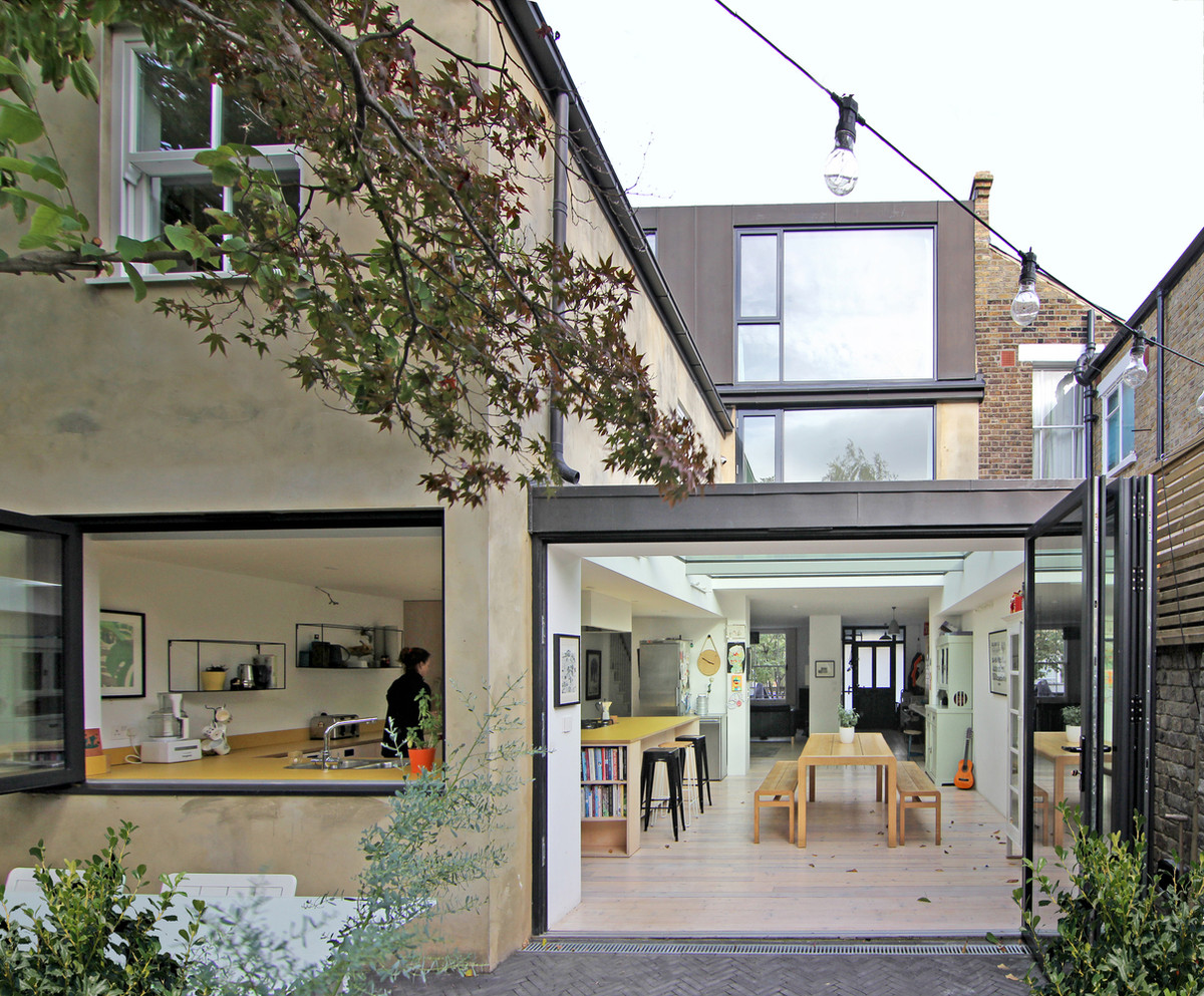 Khu vực chức năng chính của tầng 1 là bếp và bàn ăn với chất liệu gỗ mộc mạc.