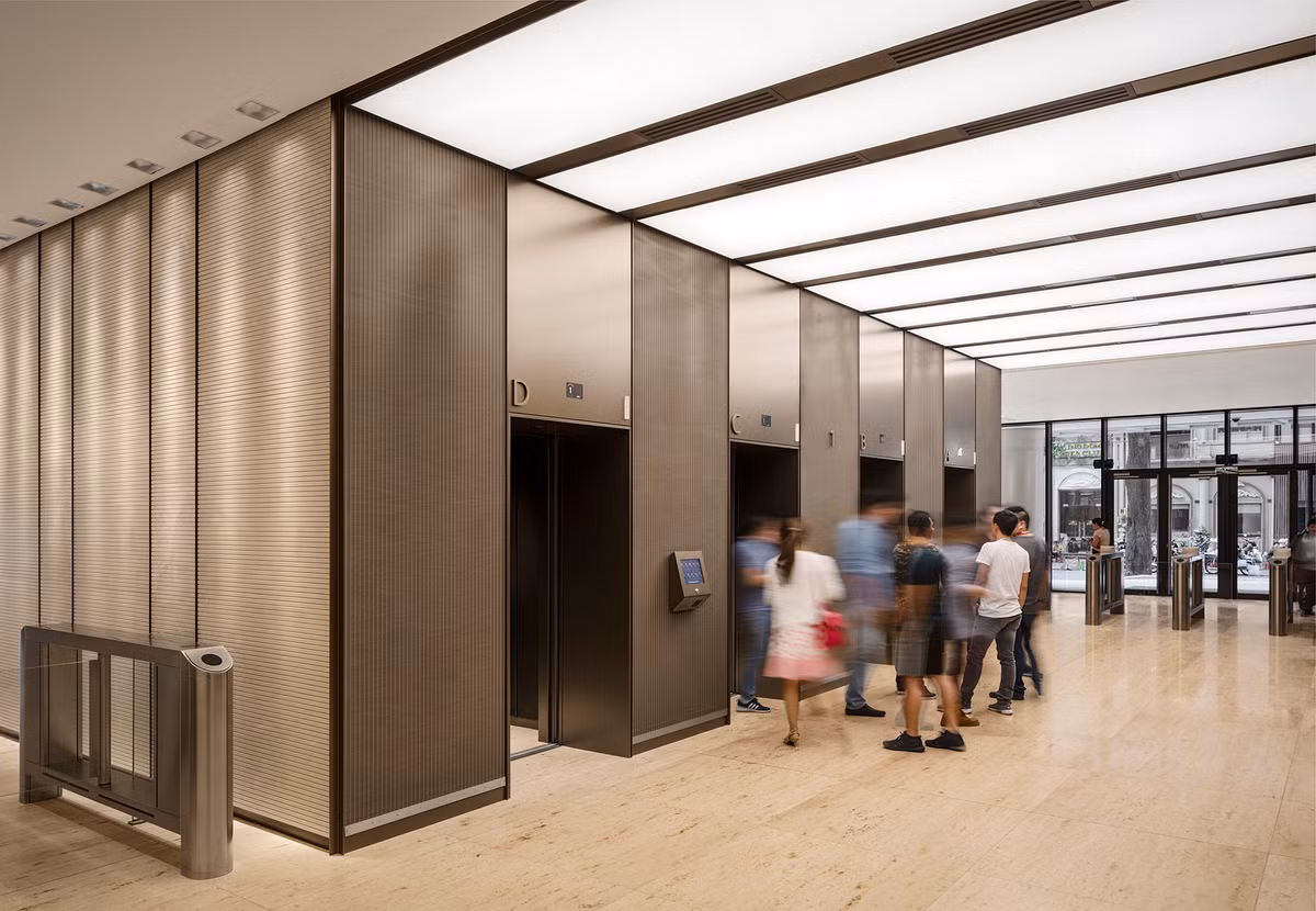 Sảnh thang máy trung tâm được phân cách với các văn phòng bằng hai hệ cửa kính vì thế ánh sáng tự nhiên có thể chiếu sáng khu vực này.