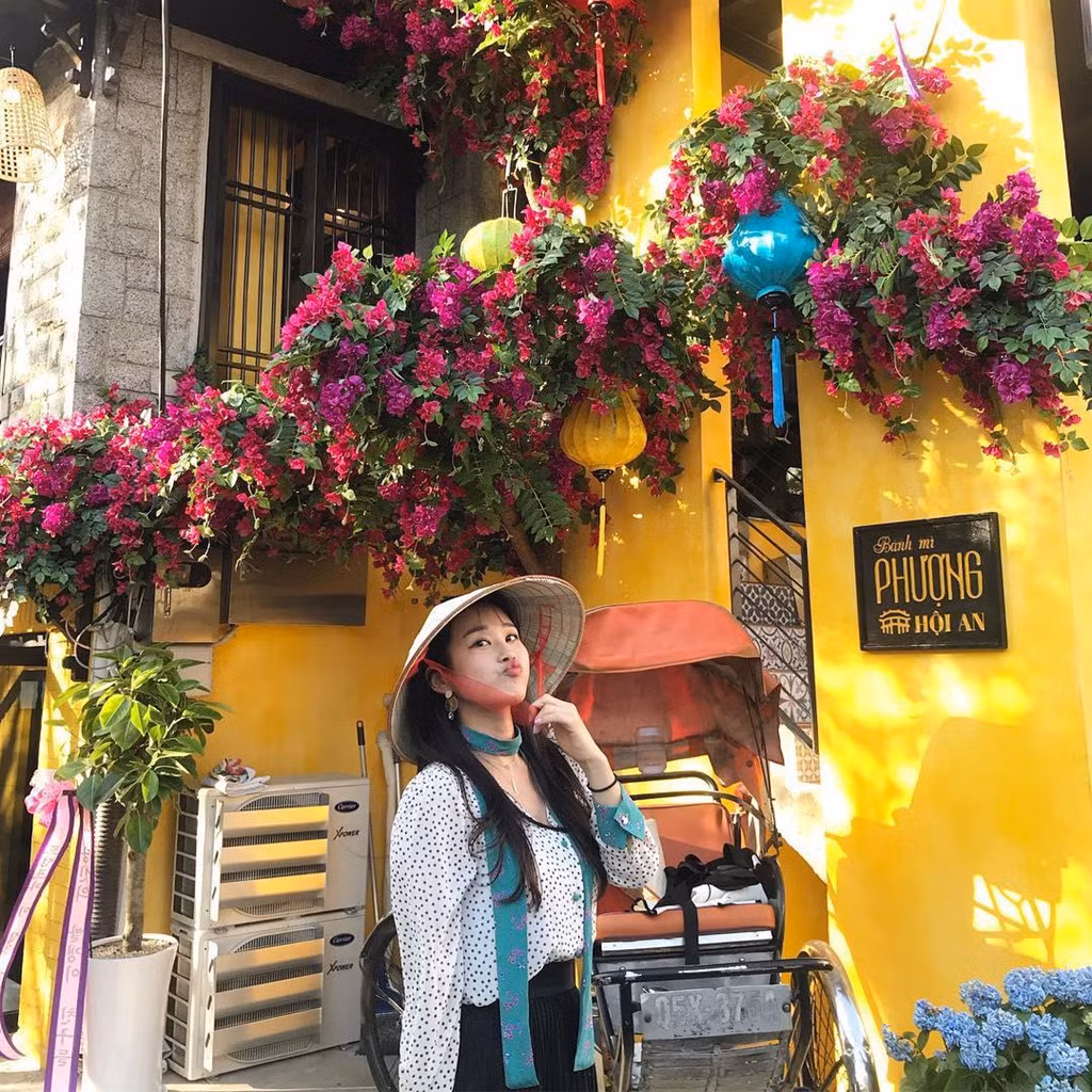 Quán rộng rãi với không gian 3 tầng thoáng đãng, được trang trí đậm nét phố Hội truyền thống với tường sơn vàng, xung quanh có hoa giấy. Ảnh: Kim Yeo Jin.