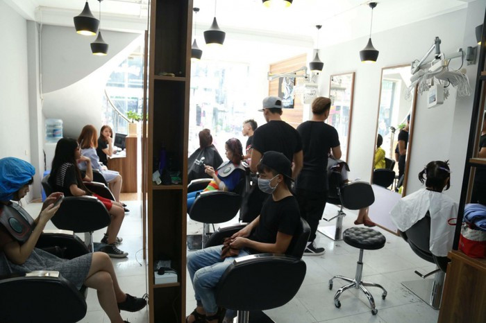 Khách đến làm và ngồi chờ kín khiến nhân viên nhiều cửa hàng làm việc liên tục không nghỉ ngơi. Ảnh: Baogiaothong.