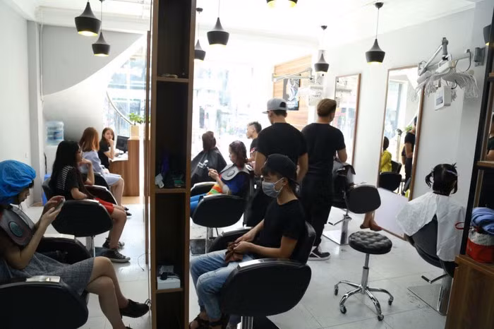 Khách đến làm và ngồi chờ kín khiến nhân viên nhiều cửa hàng làm việc liên tục không nghỉ ngơi. Ảnh: Baogiaothong.