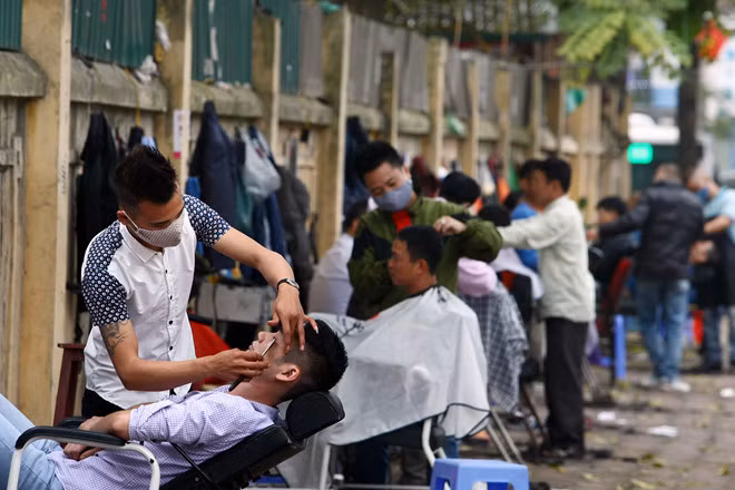 Không chỉ các tiệm, những người cắt tóc dạo cũng "bội thu" ngày cận Tết. Ảnh: Zing.