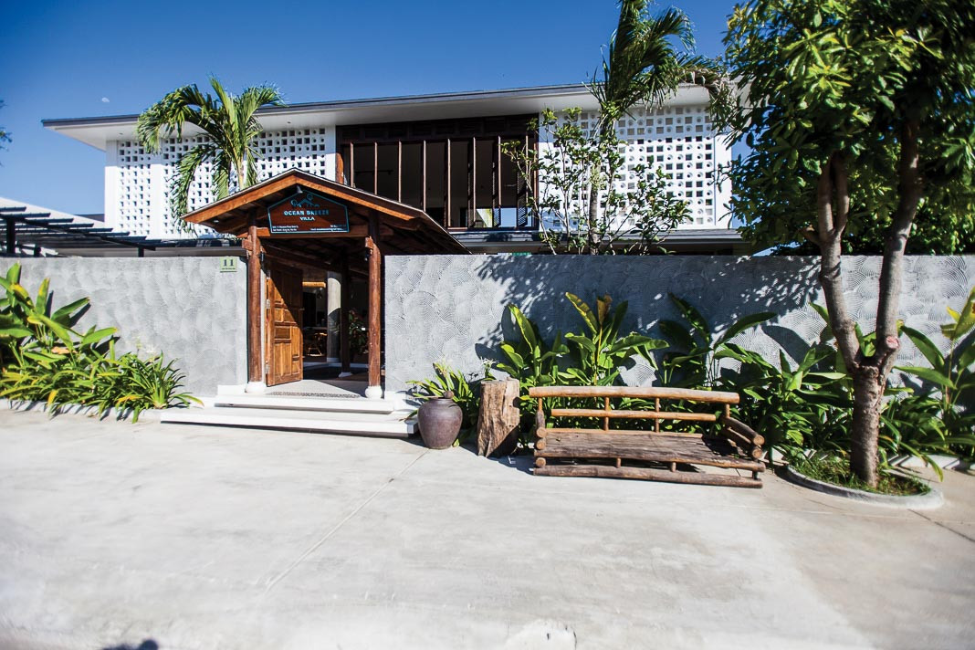 Cổng vào ngôi nhà tái hiện lại cuộc sống dân dã ngày xưa với hàng cau, bụi chuối, ghế chõng và chum đựng nước.