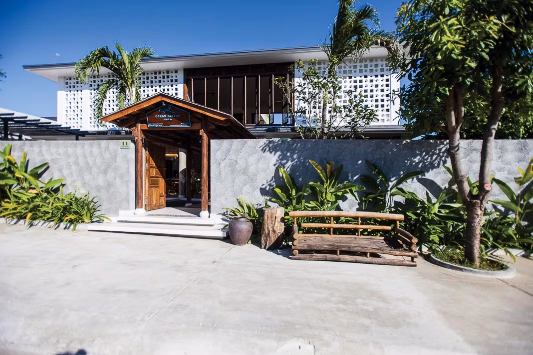 Cổng vào ngôi nhà tái hiện lại cuộc sống dân dã ngày xưa với hàng cau, bụi chuối, ghế chõng và chum đựng nước.