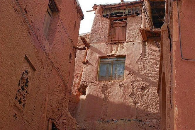 Các ngôi nhà bằng bùn có cửa sổ lưới cùng những ban công gỗ mỏng manh bám vào các dốc. Ảnh: AM.