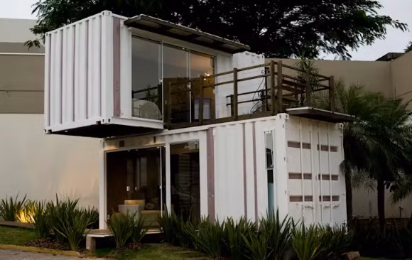 Nhà container màu trắng đẹp mắt, với những ô cửa sổ, cửa đi bằng kính hiện đại, ban công tầng 2 lớn. Ảnh: Loft-container.