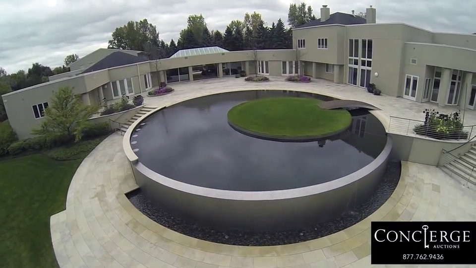 Một hồ bơi vô cực với thảm cỏ xanh mướt ở giữa.