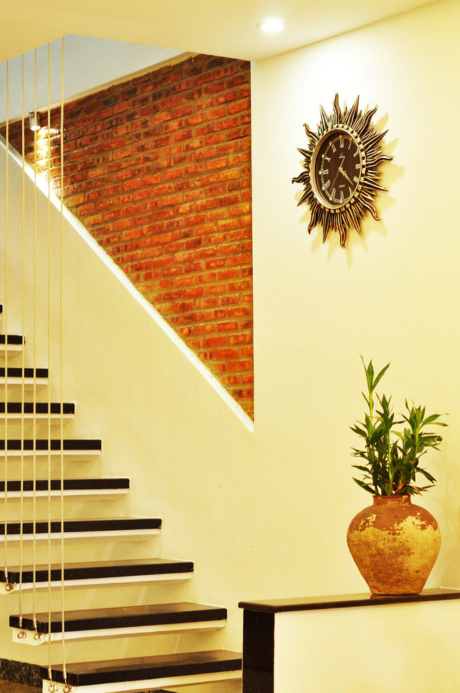 Cầu thang dây cáp kết hợp mảng tường gạch vừa hiện đại vừa mộc mạc.