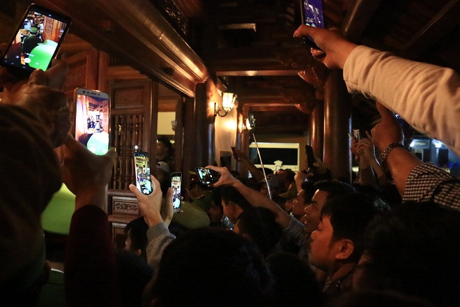 Cửa miếu Trò chật cứng người. Những chiếc điện thoại được giơ lên cao để có thể ghi lại được giây phút thiêng liêng một năm chỉ có một lần tại miếu Trò.