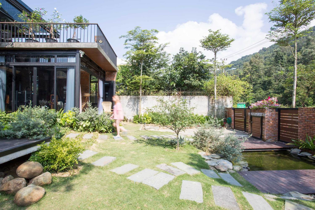 Lối vào là thảm cỏ xanh mướt có lát gạch.