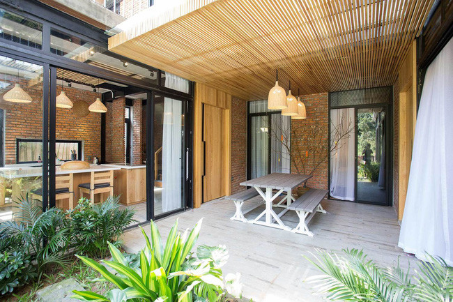 Hiên nhà kê bộ bàn ghế nhỏ thành không gian quây quầy của hai gia đình.