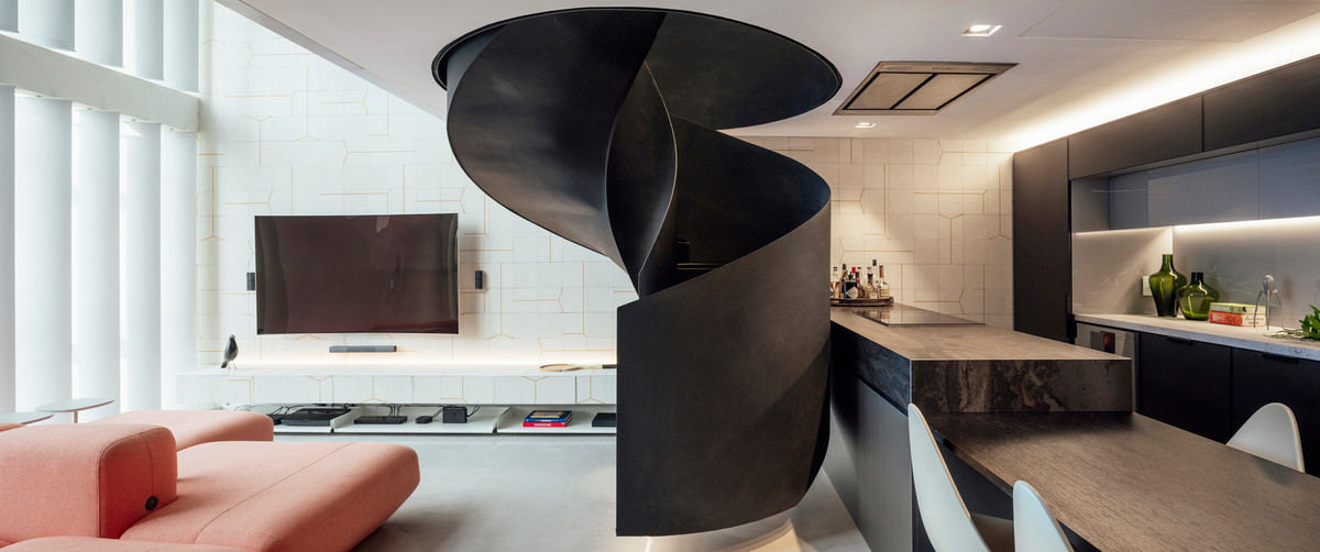 Nổi bật nhất là cầu thang xoắn màu đen đặt giữa trung tâm căn nhà, kết nối tầng trệt với tầng lửng.