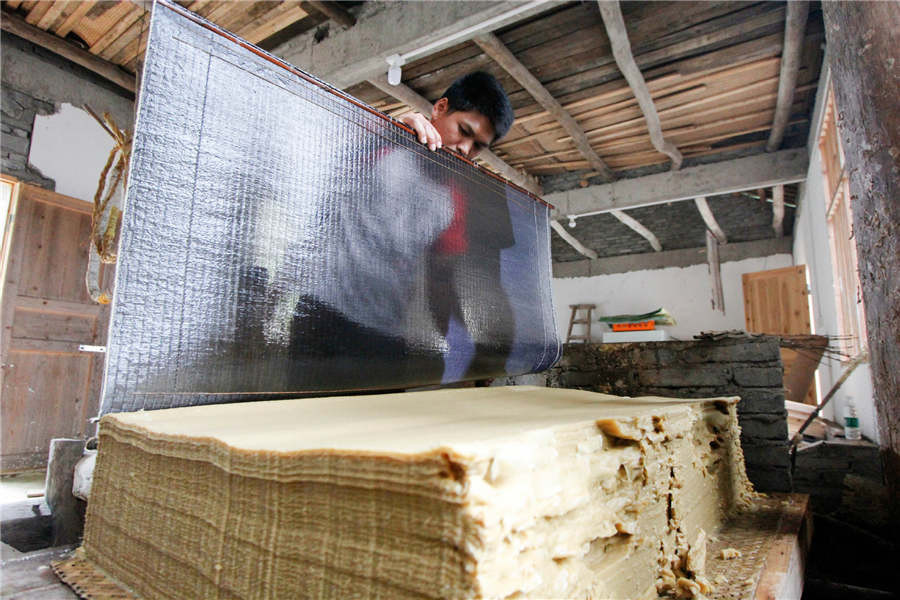 Khi nước khô, bột giấy se lại và trang giấy dần hiện ra.