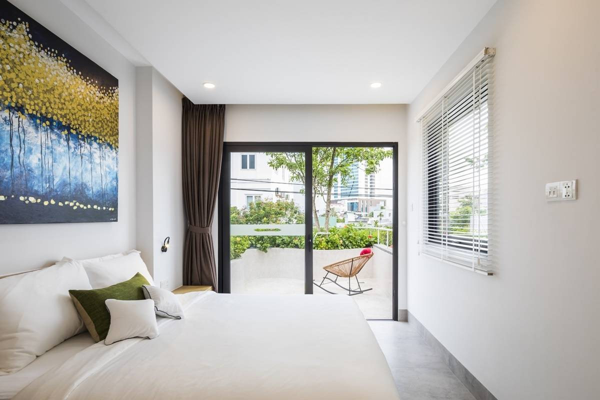 Phòng ngủ có ban công rộng, cạnh khu vườn xinh xắn.