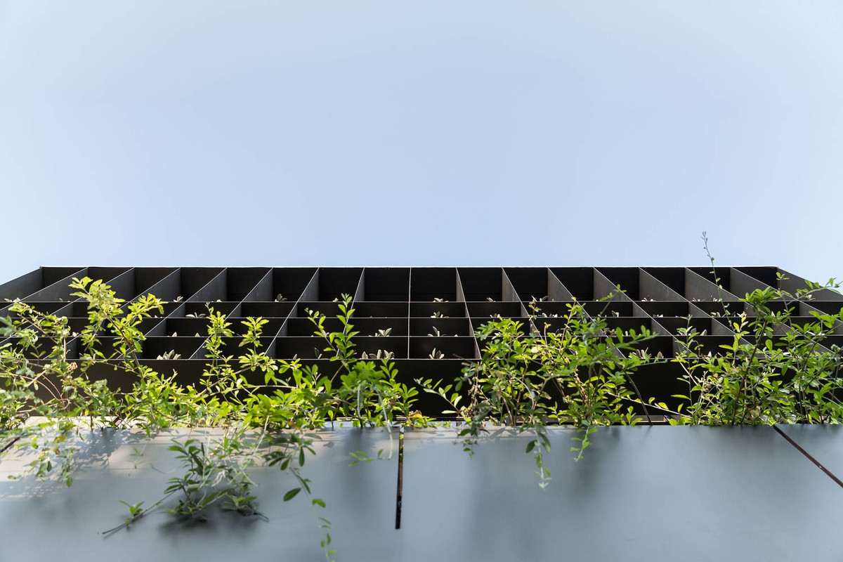 Mặt tiền tầng 2 là một giàn thép trồng cây thiết kế bên ngoài lồng kính.