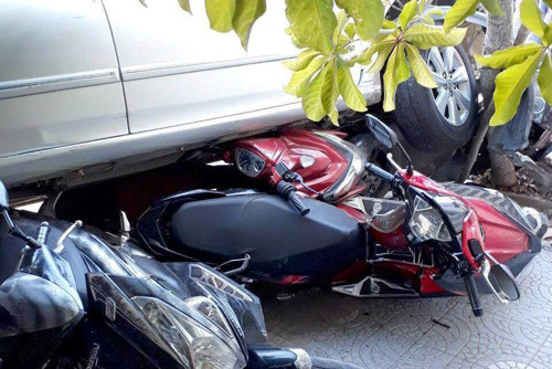 Lùi ô tô, người phụ nữ cuốn hàng loạt xe máy vào gầm - Hình 2 Lui o to, nguoi phu nu cuon hang loat xe may vao gam-Hinh-2