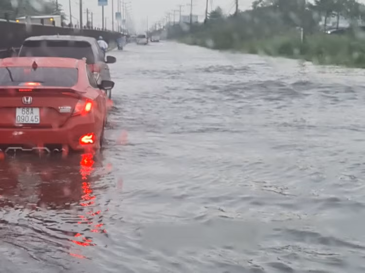 Chiều 12/6, sau cơn mưa kéo dài hơn 2 tiếng, đoạn quốc lộ 1 qua khu công nghiệp Hòa Phú, huyện Long Hồ, tỉnh Vĩnh Long biến thành sông. Ảnh: An Quý