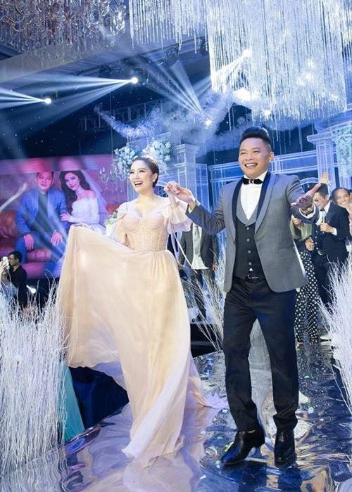 Cô được ông xã đại gia dìu đi catwalk trong tiệc cưới. Ảnh: Yan