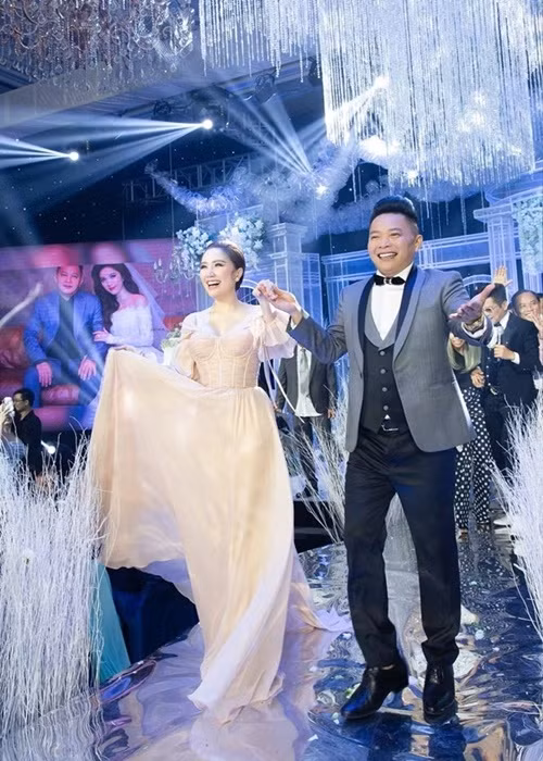 Cô được ông xã đại gia dìu đi catwalk trong tiệc cưới. Ảnh: Yan