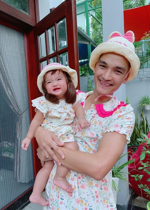 Mạc Văn Khoa dành nhiều thời gian chăm sóc con gái. Để con cười, anh đóng giả vợ, mặc váy, đội nón y chang vợ. Ảnh: FBNV