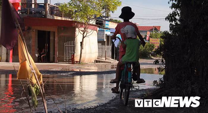 Hình ảnh cháu bé chở em bằng xe đạp cố gắng vượt qua đoạn đường ngập nước khiến nhiều người lo sợ.
