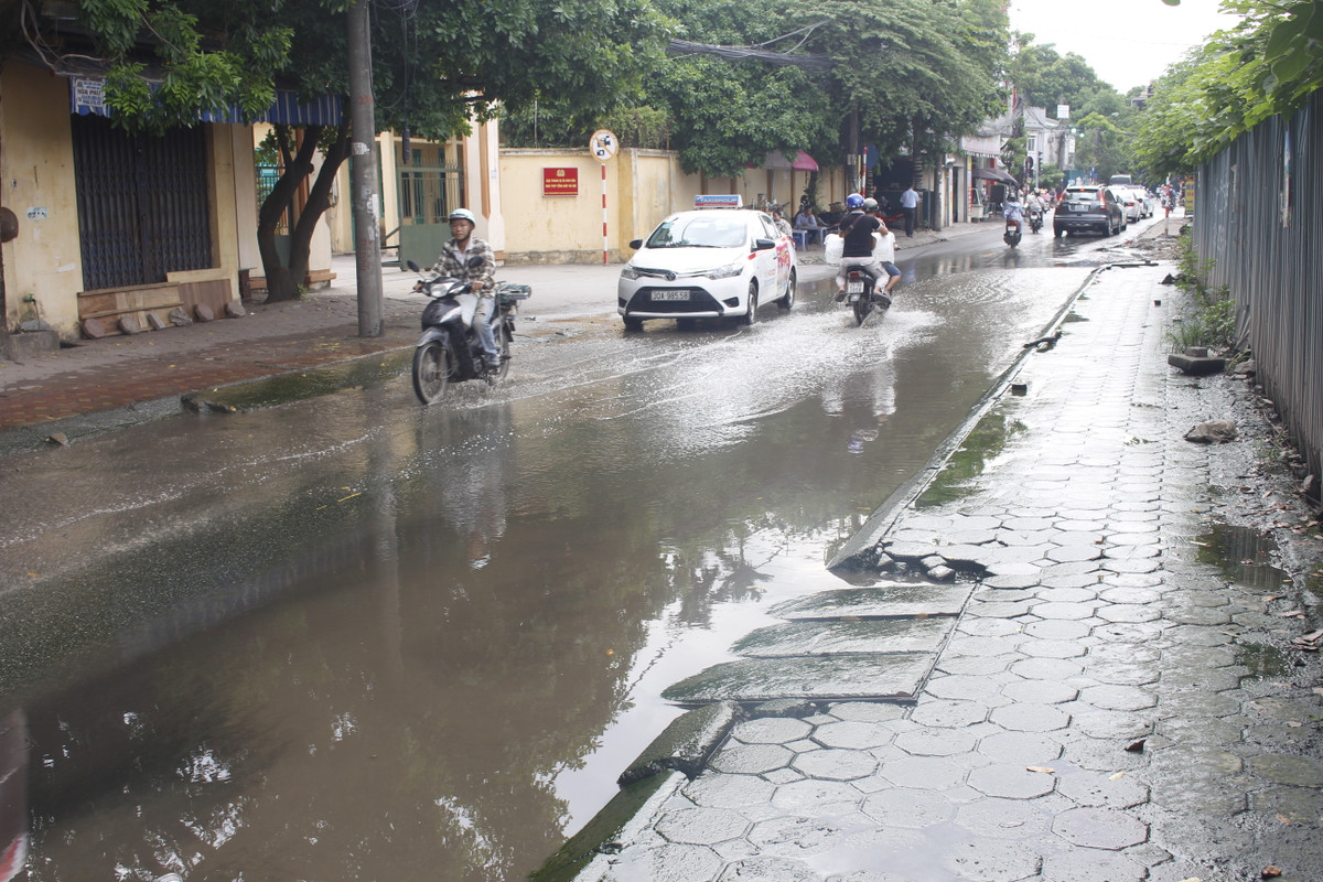 Xe máy đi qua rất thận trọng vì đường trơn, ngập.