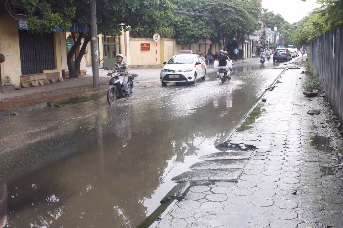 Xe máy đi qua rất thận trọng vì đường trơn, ngập.