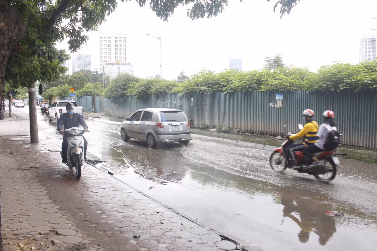 Nhiều xe máy chạy lên vỉa hè để tránh đoạn ngập nước.