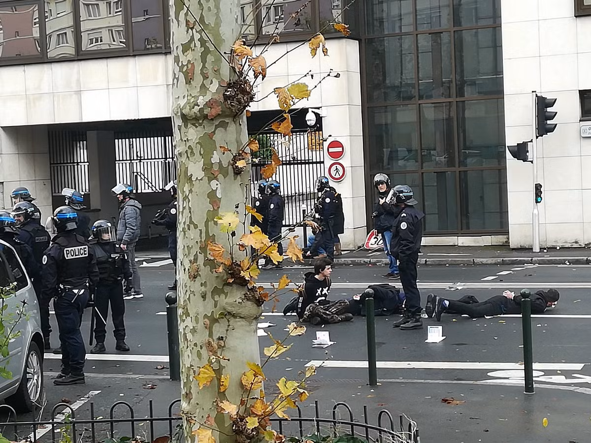 Những đoạn video và bức ảnh được đăng tải trên mạng cho thấy nhiều thanh thiếu niên bị cảnh sát bắt giữ nằm trên đường, trong khi đường phố mù mịt hơi cay và những chiếc ô tô bị lật úp hoặc thiêu rụi. Ảnh: Twitter.