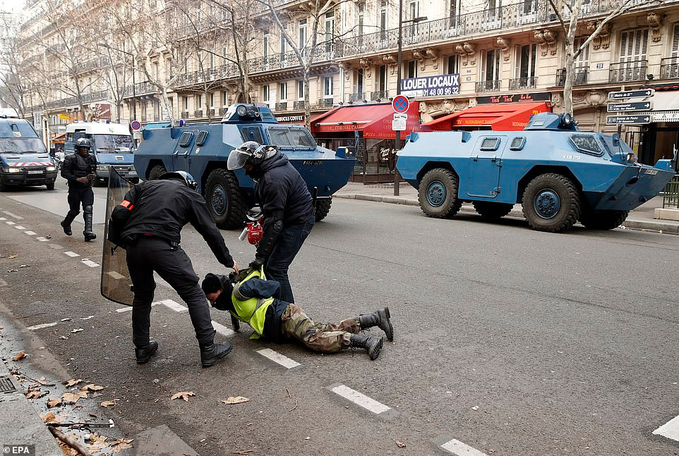 Một người biểu tình Áo vàng bị cảnh sát bắt giữ trên đường phố Paris. Ảnh: EPA.