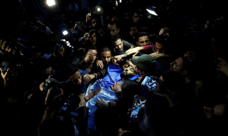 Mọi người khiêng thi thể của Ahmed Abu Hussein, một nhà báo 24 tuổi người Palestine, tại một bệnh viện ở Dải Gaza. Được biết, Ahmed đã thiệt mạng do bị thưong trong lúc đưa tin về cuộc biểu tình dọc biên giới Gaza-Israel.