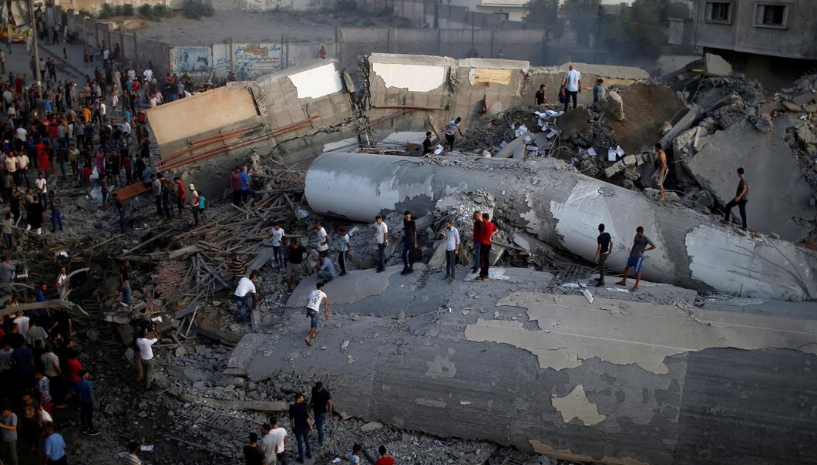 Người dân Palestine tập trung tại một toà nhà bị phá huỷ sau đợt oanh kích của Israel tại thành phố Gaza.