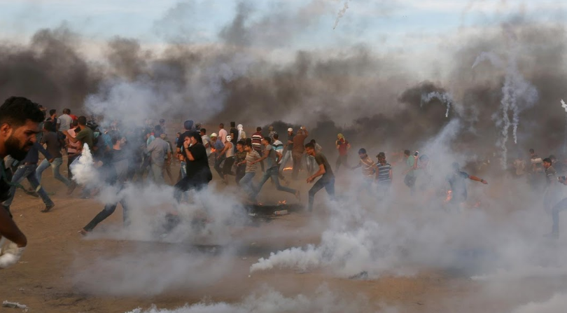 Người biểu tình Palestine bỏ chạy giữa làn khói hơi cay mù mịt trong cuộc biểu tình tại khu vực hàng rào biên giới Israel-Gaza.