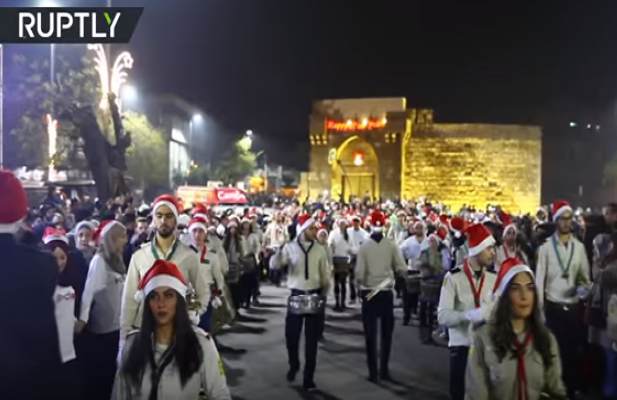 Nhiều người dân Syria đội mũ ông già Noel diễu hành trên đường phố. Ảnh: Ruptly.