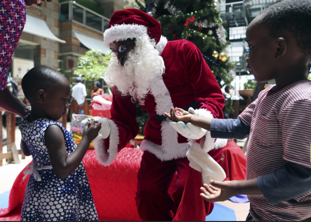 Ông già Noel phát quà cho các em nhỏ ở Harare, Zimbabwe, ngày 21/12. Ảnh: AP.