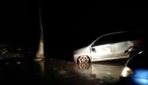 Những chiếc ô tô bị nước lũ bủa vây. Ảnh: Mirror.