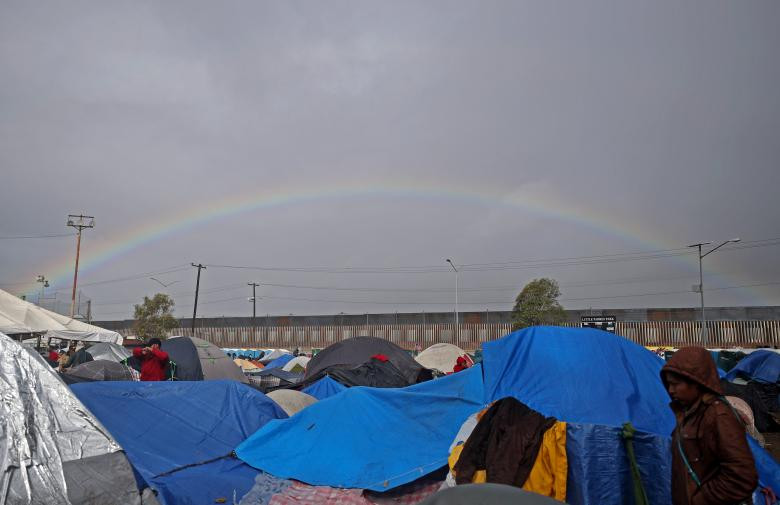Cầu vồng xuất hiện phía xa xa sau bức tường biên giới Mỹ-Mexico ở Tijuana sau trận mưa lớn.