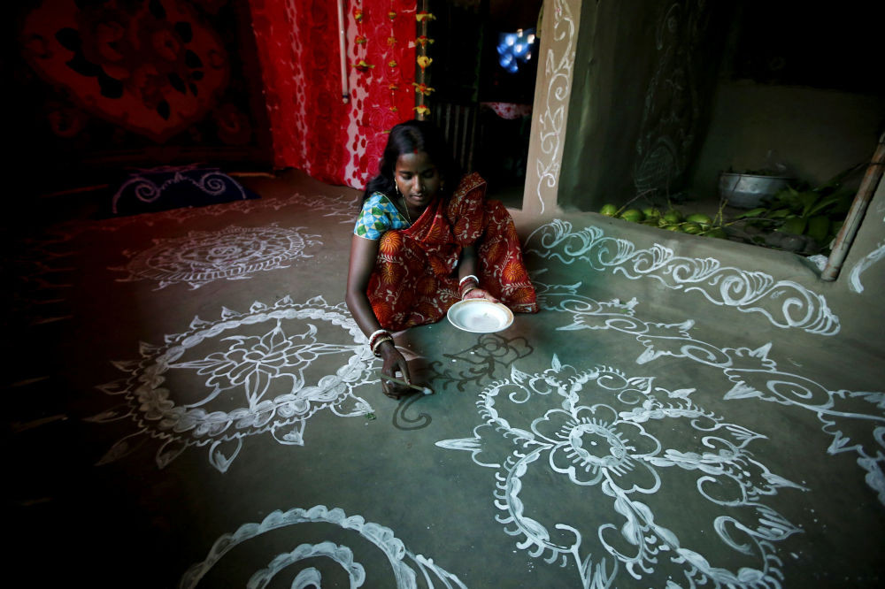 Purnima Shaw, 27 tuổi, vẽ một bức tranh trên nền nhà trong dịp lễ hội Laxmi Puja trên đảo Ghoramara ngày 24/10/2018. Ảnh: Sputnik.