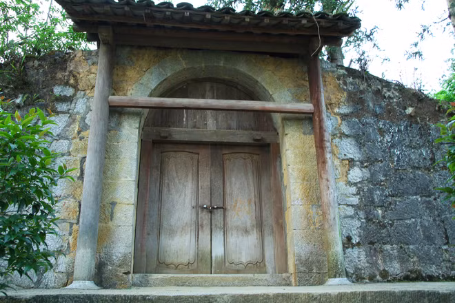 Xung quanh nhà Vương được bao bọc bởi 2 vòng tường thành đá, cao khoảng 3 m, có những lỗ châu mai.