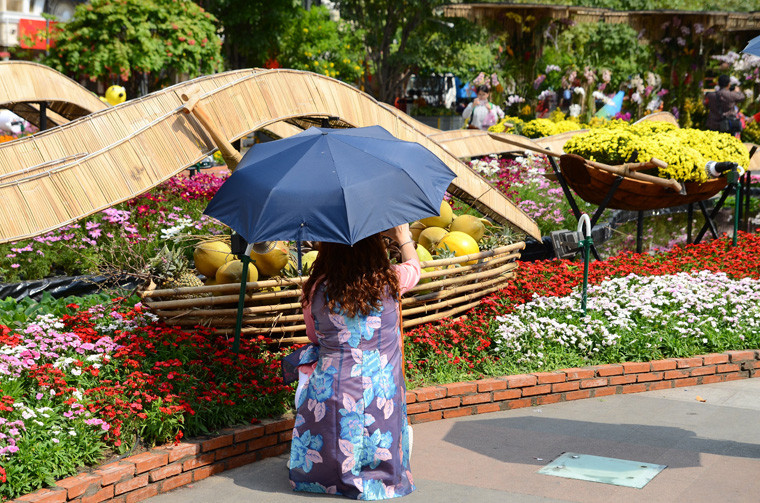 Chưa rõ người phụ nữ này đang làm gì giữa nắng nóng gay gắt trên đường hoa Nguyễn Huệ trưa Mùng 1 Tết. 