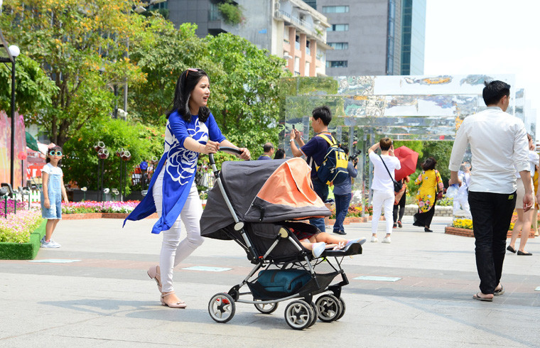 Những đứa bé được người thân trùm kín khi dạo đường hoa Nguyễn Huệ Tết Kỷ Hợi.