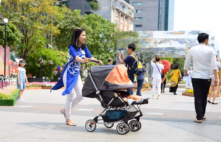 Những đứa bé được người thân trùm kín khi dạo đường hoa Nguyễn Huệ Tết Kỷ Hợi.